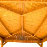 close up of finished wooden patio cover with metal chandelier hanging in middle